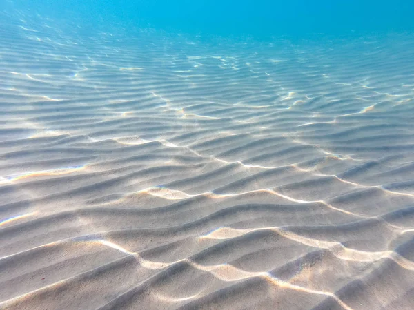 Klares Wasser. Unterwasserhintergrund mit sandigem Meeresgrund. schöne Textur des Meeres und Ozeanwassers. — Stockfoto