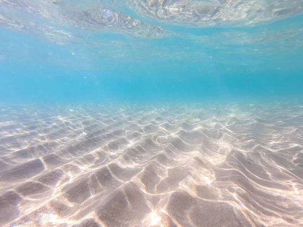 Klart vatten. undervattens bakgrund med sand havsbotten. Vacker konsistens av havet och havsvatten. — Stockfoto