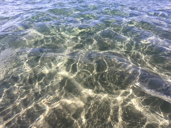 Textura čisté vody s písčitým dnem. Vlna na pobřeží nebo na moři. — Stock fotografie