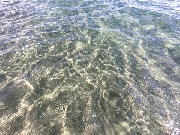 The texture of clear water with sandy bottom. Wave on the seashore or ocean. — Stock Photo, Image