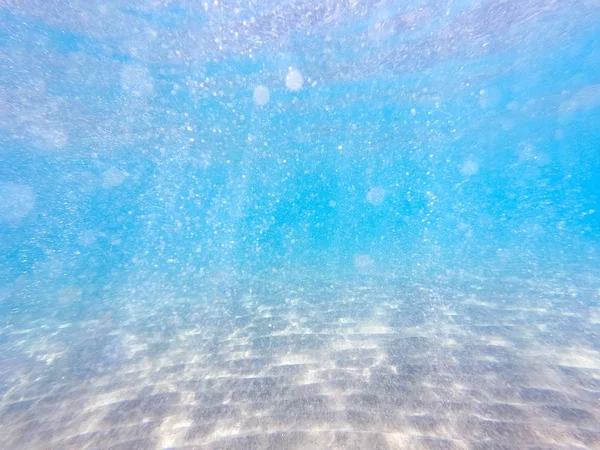 Agua clara. fondo submarino con fondo marino arenoso. Hermosa textura del mar y el agua del océano . —  Fotos de Stock