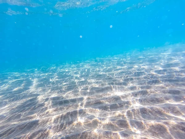 Água limpa. fundo subaquático com fundo do mar arenoso. Bela textura do mar e água do oceano . — Fotografia de Stock