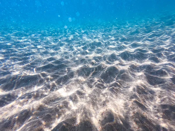 Agua clara. fondo submarino con fondo marino arenoso. Hermosa textura del mar y el agua del océano . — Foto de Stock