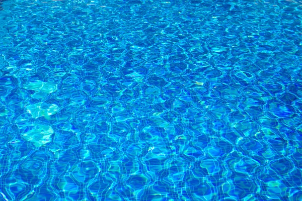 Água clara transparente na piscina. azulejos em mosaico azul, textura da água. Piscina de água azul fundo inferior . — Fotografia de Stock