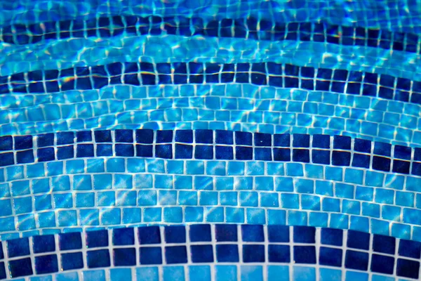 Transparent klart vatten i poolen. blå mosaikkakel, vatten konsistens. Blå vattenpool botten bakgrund. — Stockfoto