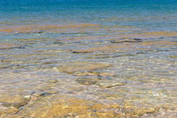 Čistá struktura vody v modré a oranžové barvě. Pozadí oceánu a moře podsvícené sluncem. Měkké vlny. Přírodní voda — Stock fotografie