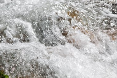 Dağdaki azgın nehirde su. Taş ve suyun güzel doğal arka planı. Temiz su ve hızlı nehir dokusu.