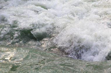 Dağdaki azgın nehirde su. Taş ve suyun güzel doğal arka planı. Temiz su ve hızlı nehir dokusu.