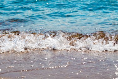 kumlu plaj ve mavi deniz dalgası. Güzel doğal arka plan. Turizm ve seyahat.