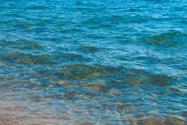 Čistá struktura vody v modré a oranžové barvě. Pozadí oceánu a moře podsvícené sluncem. Měkké vlny. Přírodní voda — Stock fotografie