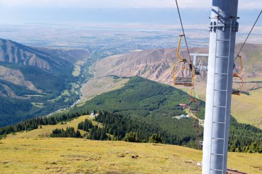 Dağlarda yüksek yaz dağları manzarası. Noel ağaçlarının uzun ağaçları, kayak tabanında kayak kaldırma..