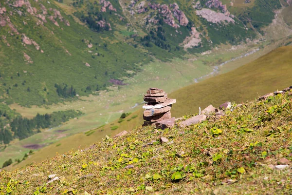 Στοίβα από πέτρες, ίχνη βράχων, σκάνε στα βουνά. Με φόντο χιονισμένα βουνά ψηλά στα βουνά. Κιργιστάν, Karakol. — Φωτογραφία Αρχείου