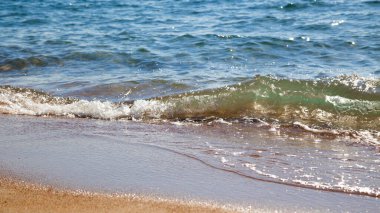 kumlu plaj ve mavi deniz dalgası. Güzel doğal arka plan. Turizm ve seyahat.