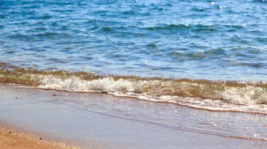 kumlu plaj ve mavi deniz dalgası. Güzel doğal arka plan. Turizm ve seyahat.