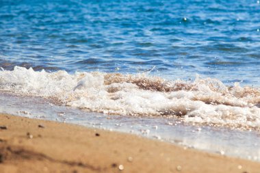 kumlu plaj ve mavi deniz dalgası. Güzel doğal arka plan. Turizm ve seyahat.