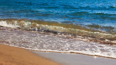 kumlu plaj ve mavi deniz dalgası. Güzel doğal arka plan. Turizm ve seyahat.