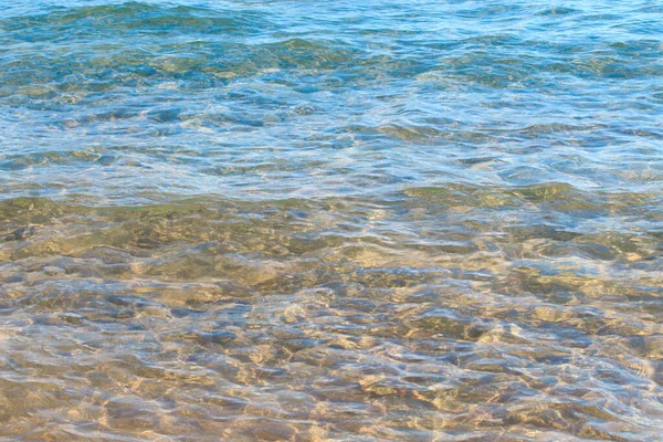 Čistá struktura vody v modré a oranžové barvě. Pozadí oceánu a moře podsvícené sluncem. Měkké vlny. Přírodní voda — Stock fotografie