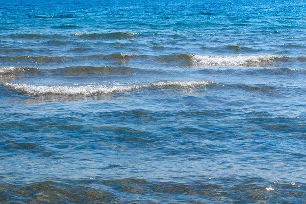 Чиста текстура води синім і помаранчевим кольором. Тло океану і морська підсвітка сонцем. М'які хвилі. Природна вода — стокове фото
