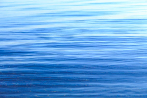 ブルーとオレンジの透明感のある水の質感。太陽に照らされた海と海の背景。波が柔らかい天然水 — ストック写真