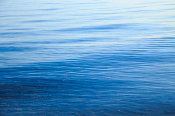 Чистая вода текстуры в синий и оранжевый. Фон океана и моря, подсвеченные солнцем. Мягкие волны. Естественная вода — стоковое фото