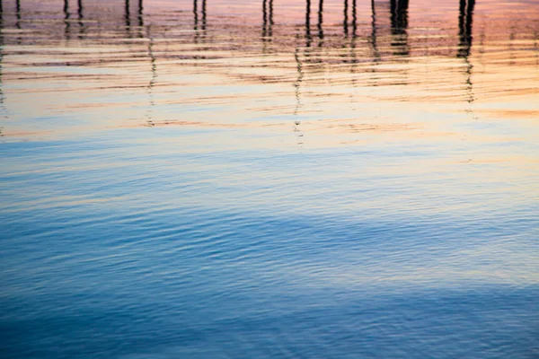 Klar vattenstruktur i blått och orange. Bakgrund av havet och havet bakgrundsbelyst av solen. Mjuka vågor. Naturligt vatten — Stockfoto