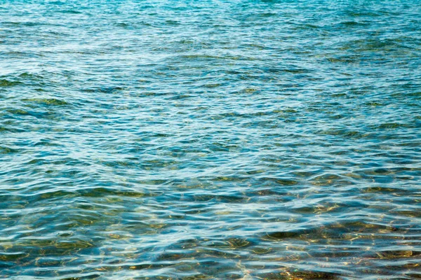 Mavi ve turuncu berrak su dokusu. Okyanusun arka planı ve güneş tarafından aydınlatılan deniz. Yumuşak dalgalar. Doğal su. — Stok fotoğraf
