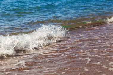 kumlu plaj ve mavi deniz dalgası. Güzel doğal arka plan. Turizm ve seyahat.