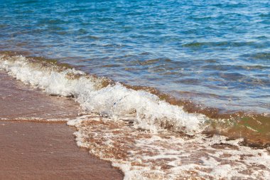 kumlu plaj ve mavi deniz dalgası. Güzel doğal arka plan. Turizm ve seyahat.