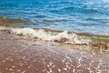 kumlu plaj ve mavi deniz dalgası. Güzel doğal arka plan. Turizm ve seyahat.