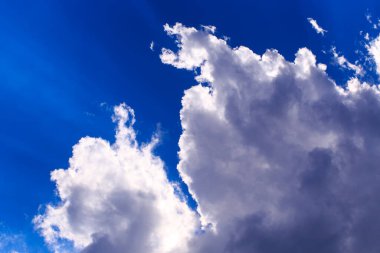 Mavi gökyüzüne karşı parlak kümülüs bulutları. Günbatımı gökyüzü Doğal arkaplan