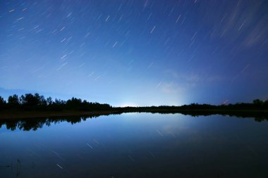 Yıldızlı gökyüzü ve bulutlar. Gece manzarası, denizlere ve dağlara yansıyan ışıklar..