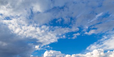 Mavi gökyüzüne karşı parlak kümülüs bulutları. Doğal arkaplan.