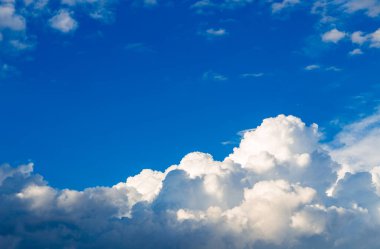 Mavi gökyüzüne karşı parlak kümülüs bulutları. Doğal arkaplan.