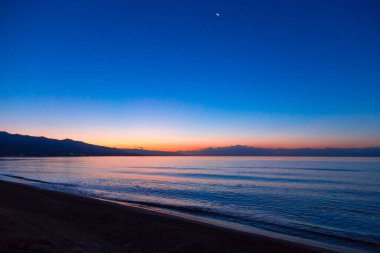 Denizde güneşin doğuşu. Dağların ardında yükselen güneş.