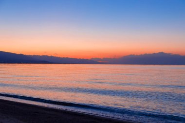 Denizde güneşin doğuşu. Dağların ardında yükselen güneş.