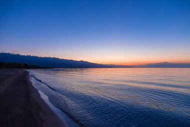 Denizde güneşin doğuşu. Dağların ardında yükselen güneş.