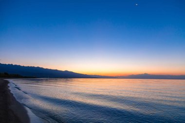 Denizde güneşin doğuşu. Dağların ardında yükselen güneş.