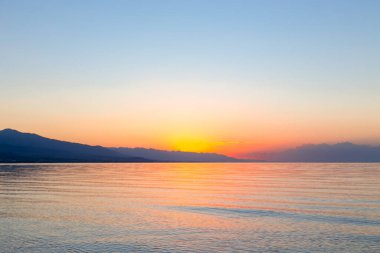 Denizde güneşin doğuşu. Dağların ardında yükselen güneş.