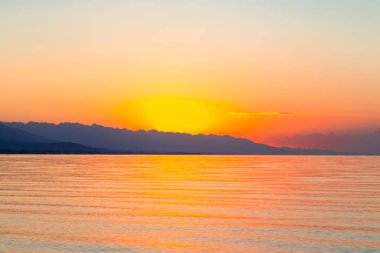Denizde güneşin doğuşu. Dağların ardında yükselen güneş.