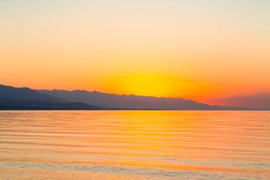 Denizde güneşin doğuşu. Dağların ardında yükselen güneş.