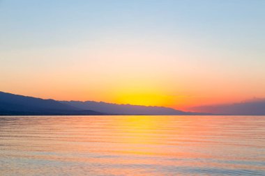 Denizde güneşin doğuşu. Dağların ardında yükselen güneş.