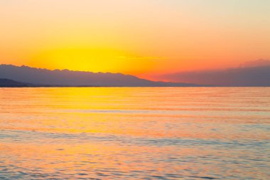 Denizde güneşin doğuşu. Dağların ardında yükselen güneş.