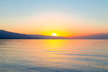 Denizde güneşin doğuşu. Dağların ardında yükselen güneş.