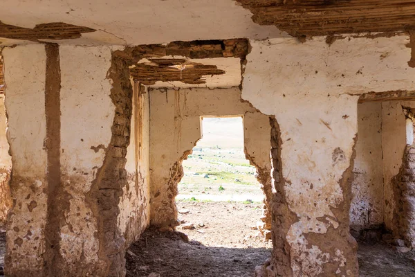 An old abandoned house. No people. The building is made of adobe and wood.