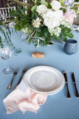 Bir tabak şeftali peçeteye gökyüzü mavi masa örtüsü, masada buket dekore