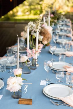 Çiçek ve mum mavi masa örtüsü üzerinde gümüş bir şamdan ile dekore edilmiş Festival tablo