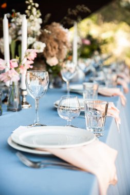 Çiçekler ve mumlarla süslenmiş mavi masa örtüsü ile Festival tablo