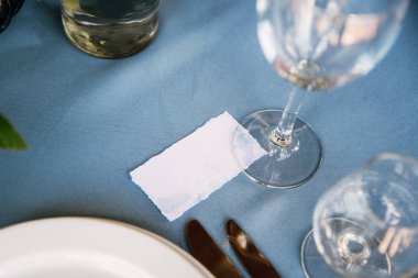 Gökyüzü mavi masa örtüsü ile dekore edilmiş bir tabloda konuk kartı