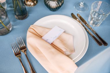 Plaka, şarap, gözlük ve çatal ile üzerinde peçete ve Konuk kart ile yanında bıçaklar