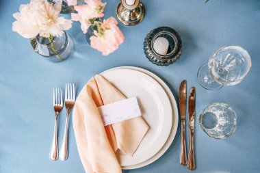 Plaka, şarap, gözlük ve çatal ile üzerinde peçete ve Konuk kart ile yanında bıçaklar